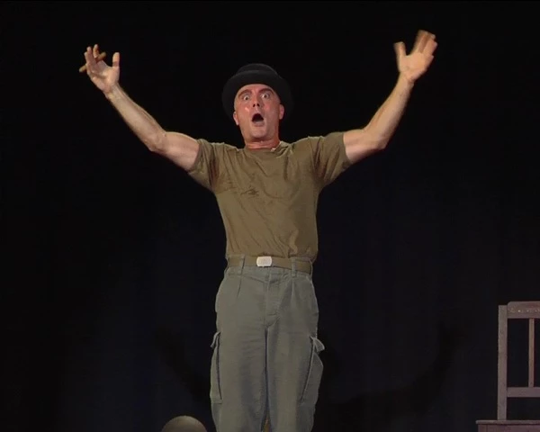 Alessandro Albertin in scena con le mani alzate ed espressione di stupore in Lo Sbarco in Normandia
