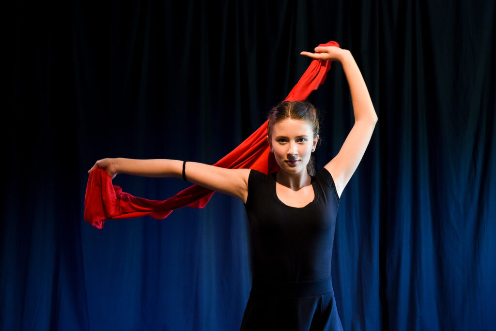 Allieva del corso di teatro Ragazzi di SpazioMio Scuola di Teatro gioca in scena con scialle rosso