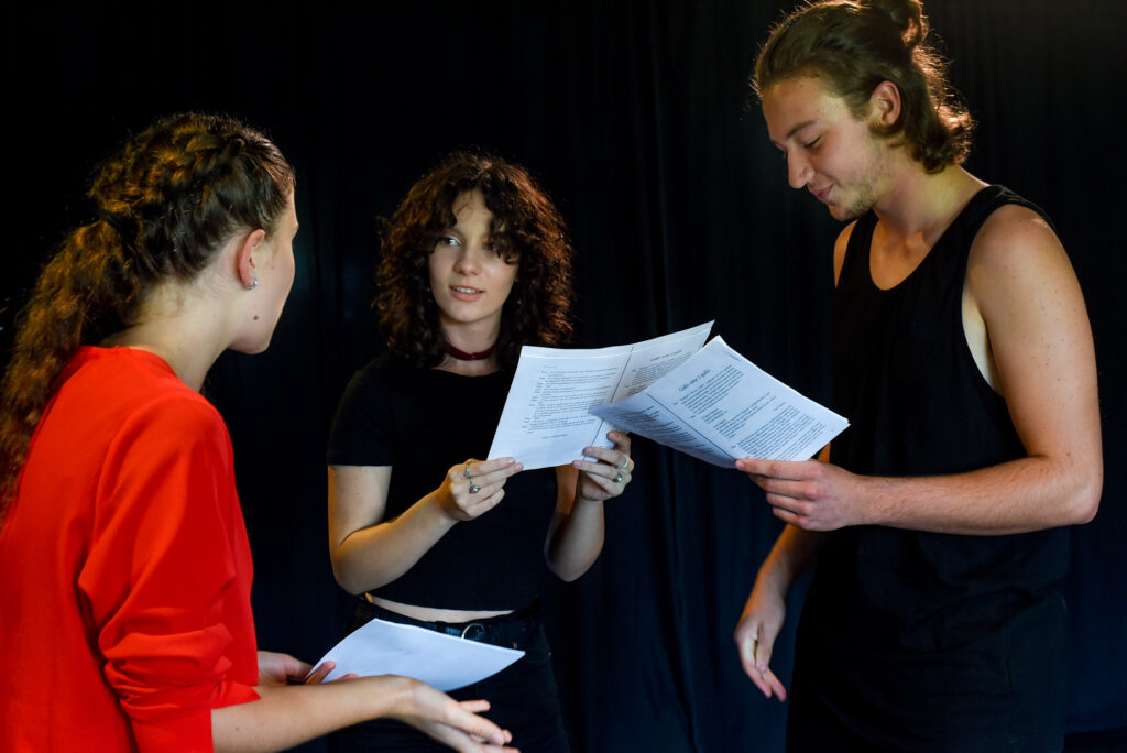 Tre allievi del corso di teatro per Ragazzi provano in scena leggendo il copione